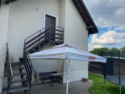 a patio with a table and an umbrella next to a staircase at Urokliwy Zakątek to apartament tylko dla Państwa in Osiek
