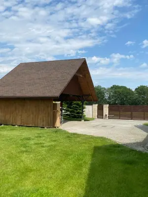 a barn with a roof on a field of grass at Urokliwy Zakątek to apartament tylko dla Państwa in Osiek