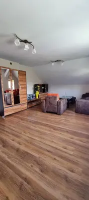 a living room with two couches and a wooden floor at Prywatny pokój z kuchnią i łazienką in Mszana Dolna