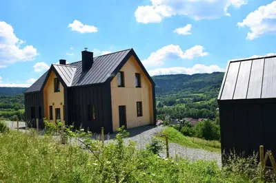 a house sitting on top of a snow covered hill at Osada Dzikie Wino in Budzów