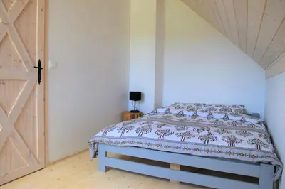 a bedroom with a bed with a wooden ceiling at Osada Dzikie Wino in Budzów