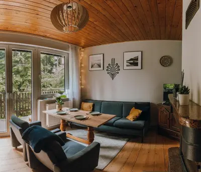 a living room with a couch and a table at Leśne zacisze - dom z kominkiem i balią in Jordanów
