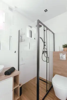 a bathroom with a shower and a toilet at Leśne zacisze - dom z kominkiem i balią in Jordanów