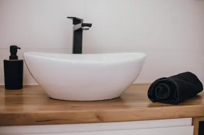 a white sink on a wooden counter with a black towel at Leśne zacisze - dom z kominkiem i balią in Jordanów