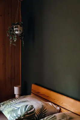 a bedroom with a bed and a green wall at Leśne zacisze - dom z kominkiem i balią in Jordanów