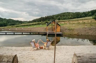 two people are laying in chairs on a beach at Apartamenty Na Potokach in Żegocina
