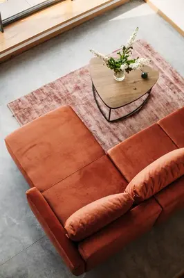 a brown couch and a table with a vase of flowers at Apartamenty Na Potokach in Żegocina