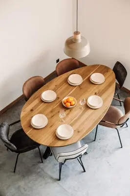 a wooden table with chairs and a bowl of fruit on it at Apartamenty Na Potokach in Żegocina
