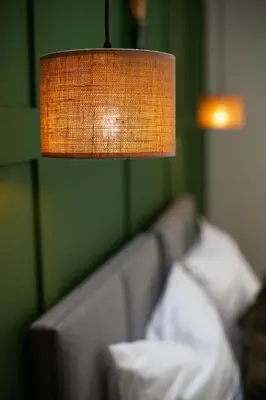 a lamp hanging over a couch with a pillow at Apartamenty Na Potokach in Żegocina