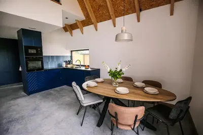 a kitchen and dining room with a wooden table and chairs at Apartamenty Na Potokach in Żegocina
