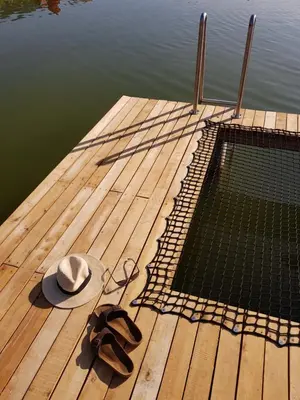 a hat and pair of sandals sitting on a dock at Apartamenty Na Potokach in Żegocina