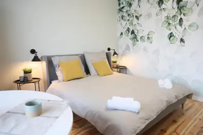 a bedroom with a bed with yellow and white pillows at Złota#208 in Złota