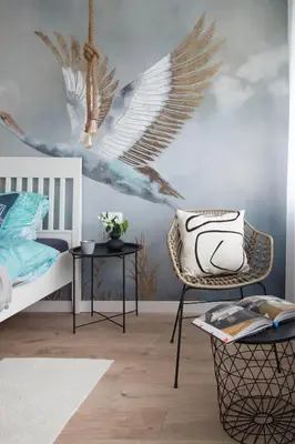 a bedroom with a bed and a chair and a wall with wings at Złota#208 in Złota