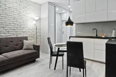 a kitchen and living room with a table and a couch at Apartament Nowa Huta in Kraków