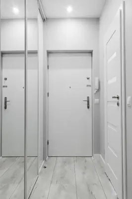 an empty corridor with two doors and a mirror at Apartament Nowa Huta in Kraków