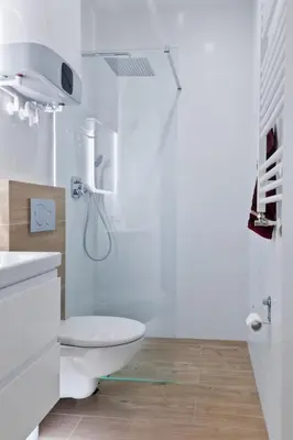 a white bathroom with a toilet and a shower at Apartament Nowa Huta in Kraków