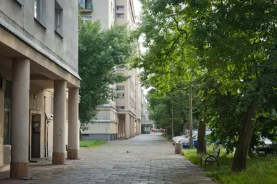 an empty city street with trees and buildings at Apartament Nowa Huta in Kraków