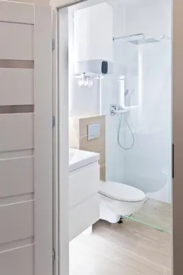 a white bathroom with a toilet and a shower at Apartament Nowa Huta in Kraków