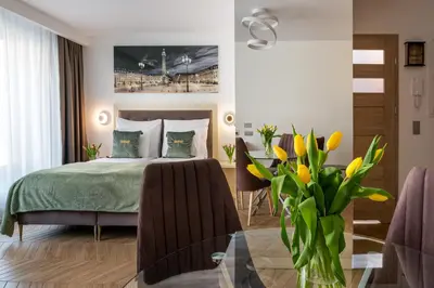 a hallway with a black door and a painting on the wall at InPoint Apartments G15 near Old Town & Kazimierz District & Optional Paid Parking in Kraków