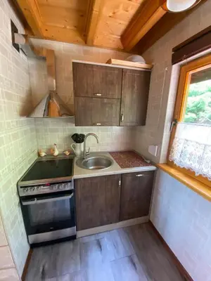a small kitchen with a sink and a stove at Urlopowa Chata in Targanice