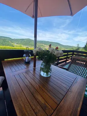 a wooden table with a vase of flowers on it at Urlopowa Chata in Targanice