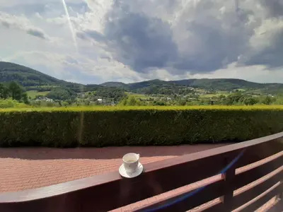 a coffee cup sitting on a bench with a view at Urlopowa Chata in Targanice