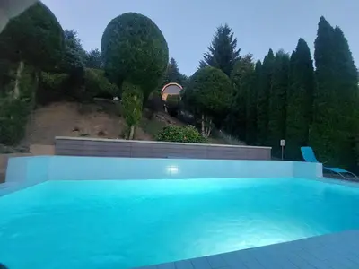 a large blue swimming pool in front of trees at Urlopowa Chata in Targanice