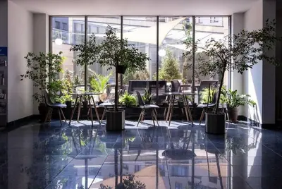a room with tables and chairs and plants in a building at Premium Apartment for Jewish Quarter & Old Town plus Pool in Kraków