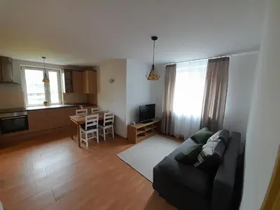 a living room with a couch and a kitchen at Apartament Koninki in Koninki
