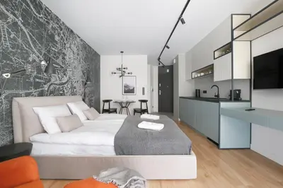 a bedroom with a large bed and a kitchen at Deluxe Studio Cracow Ariańska by Noclegi Renters in Kraków