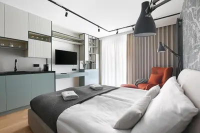 a bedroom with a bed and a living room at Deluxe Studio Cracow Ariańska by Noclegi Renters in Kraków