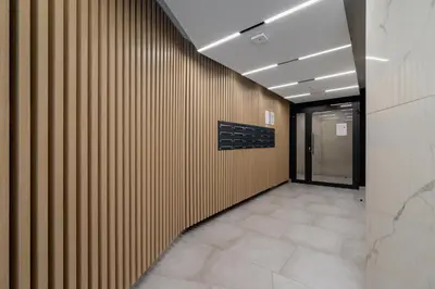 a hallway with a wooden wall in a building at Deluxe Studio Cracow Ariańska by Noclegi Renters in Kraków