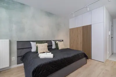 a bedroom with a large bed with black sheets and pillows at Deluxe Studio Cracow Ariańska by Noclegi Renters in Kraków