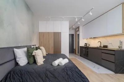 a bedroom with a large bed and a large screen at Deluxe Studio Cracow Ariańska by Noclegi Renters in Kraków