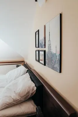 a bedroom with a bed and pictures on the wall at Zarabie Residence in Myślenice