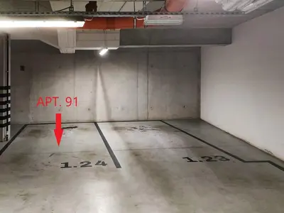 an empty parking garage with a red arrow on the wall at Rakowicka Apartments with tarrace, AC and free parking in Kraków