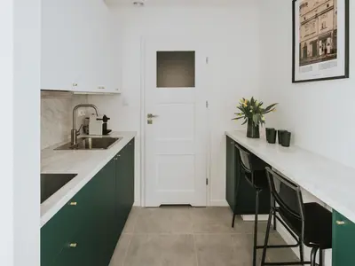 a kitchen with green cabinets and a sink at S18 Apartments in Kraków