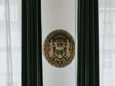 a gold door knocker on a window with green curtains at S18 Apartments in Kraków