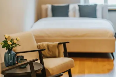a bedroom with a couch and a vase with flowers on a table at S18 Apartments in Kraków