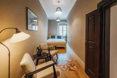 a room with a bed and a table and a lamp at S18 Apartments in Kraków