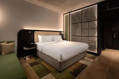 a bedroom with a large white bed and a window at Hyatt Place Krakow in Kraków