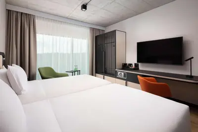 a hotel room with two beds and a flat screen tv at Hyatt Place Krakow in Kraków