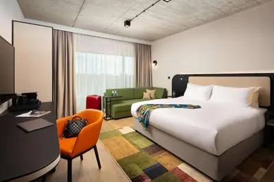 a hotel room with a bed and a chair at Hyatt Place Krakow in Kraków
