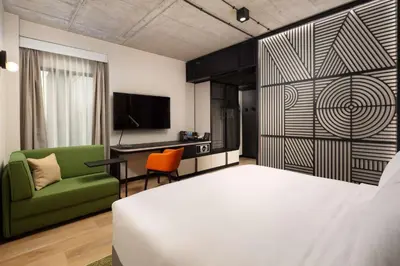 a bedroom with a bed and a chair and a desk at Hyatt Place Krakow in Kraków
