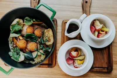 a table with a pan of food and a bowl of fruit at Hyatt Place Krakow in Kraków