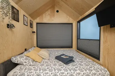 a bedroom with a bed in a tiny house at Aurora Green Hill in Podobin