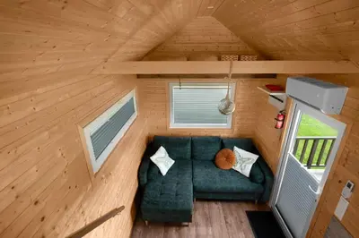 an overhead view of a green couch in a tiny house at Aurora Green Hill in Podobin