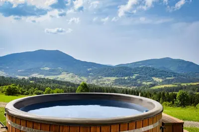 a hot tub with a view of mountains at Aurora Green Hill in Podobin