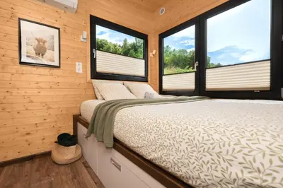 a bedroom with wooden walls and windows with a bed at Aurora Green Hill in Podobin