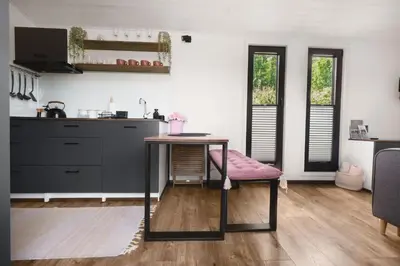 a kitchen with a table with a pink seat at Aurora Green Hill in Podobin